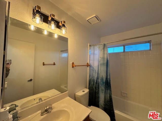 full bathroom featuring vanity, toilet, and shower / bath combo with shower curtain