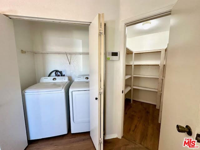 clothes washing area with dark hardwood / wood-style flooring and washer and dryer