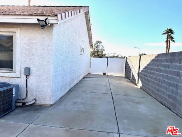 view of side of property featuring central AC and a patio