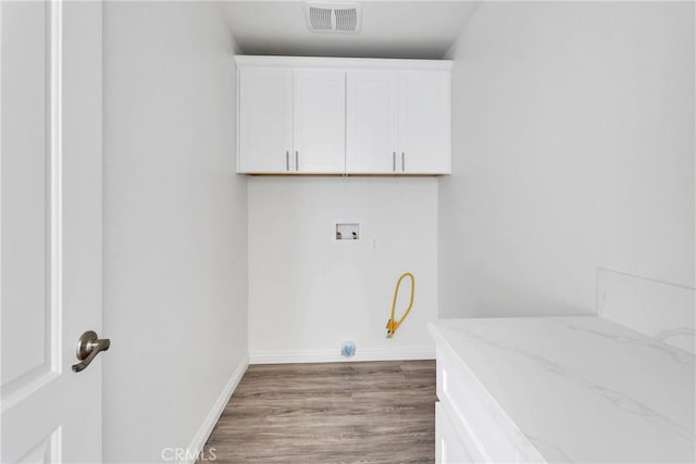 washroom with cabinets, hookup for a washing machine, and dark wood-type flooring