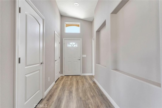 entryway with light hardwood / wood-style floors and lofted ceiling