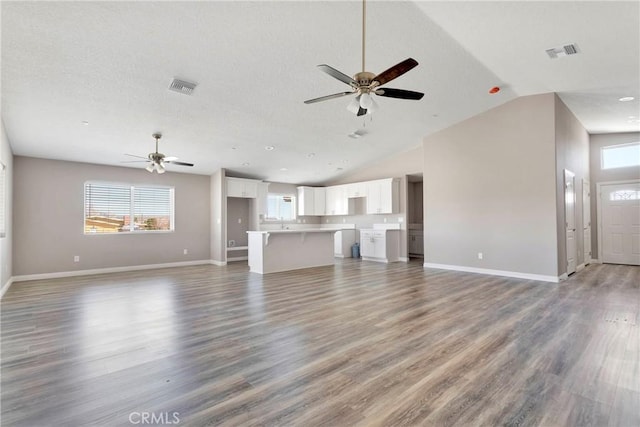 unfurnished living room featuring ceiling fan, high vaulted ceiling, and wood-type flooring