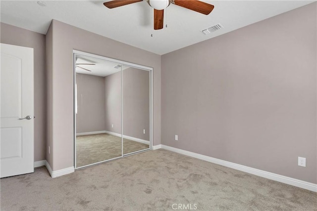 unfurnished bedroom featuring light carpet, a closet, and ceiling fan