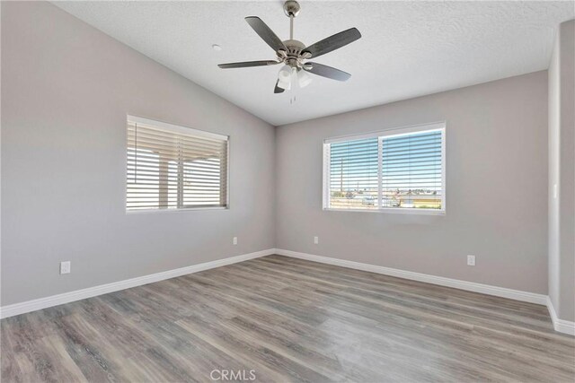 unfurnished room with a textured ceiling, ceiling fan, hardwood / wood-style floors, and lofted ceiling