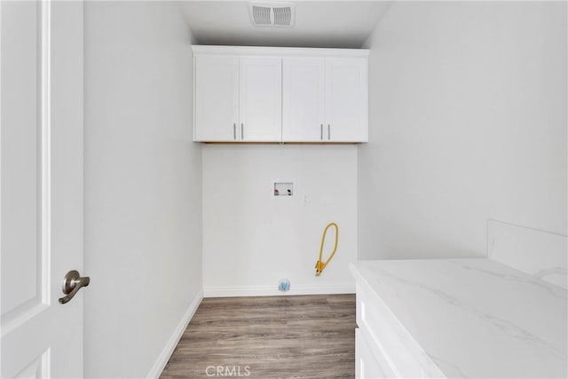 washroom featuring cabinets, washer hookup, and dark wood-type flooring