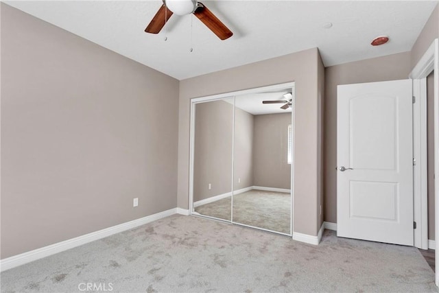 unfurnished bedroom featuring ceiling fan, light carpet, and a closet