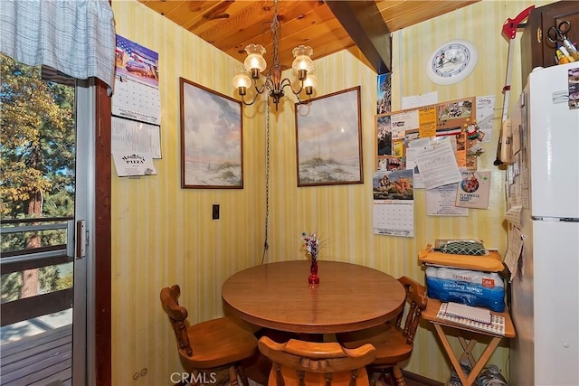 dining space with plenty of natural light, wooden walls, and a chandelier