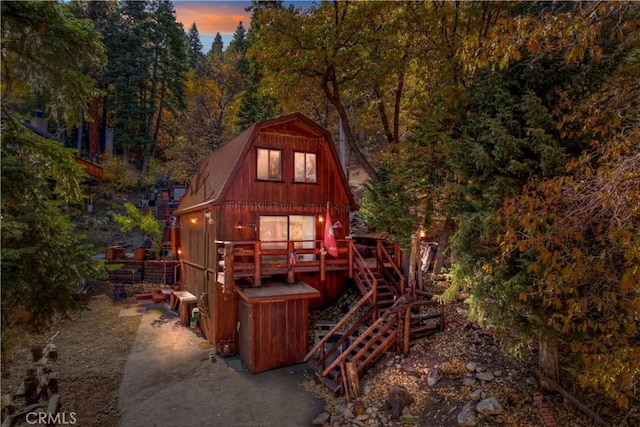 back house at dusk with a deck