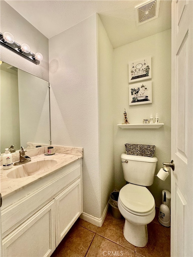 bathroom featuring tile patterned flooring, vanity, and toilet