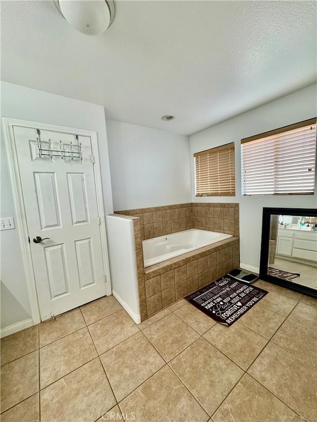 bathroom with tile patterned flooring, a bath, and baseboards