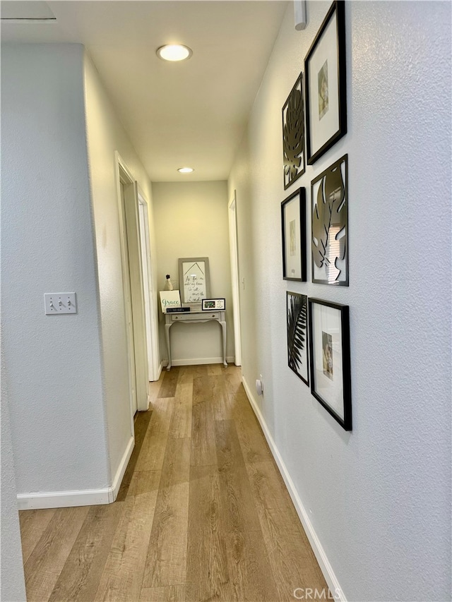 hallway with light hardwood / wood-style floors