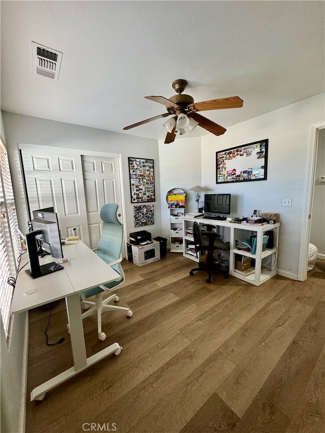 home office featuring hardwood / wood-style floors, a textured ceiling, and ceiling fan