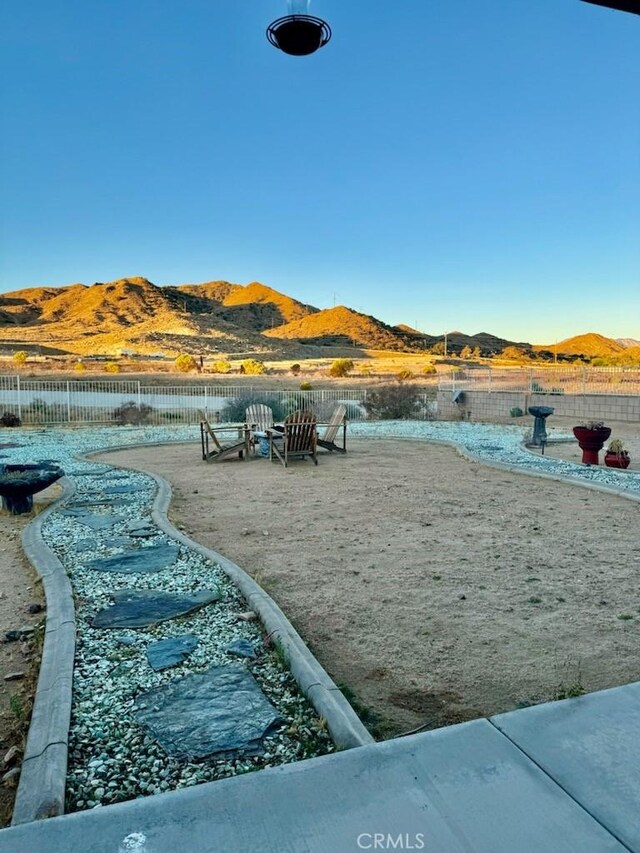 view of home's community with a patio, fence, and a mountain view