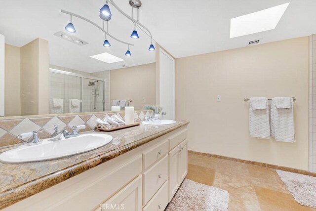 bathroom with vanity, a skylight, an enclosed shower, and backsplash