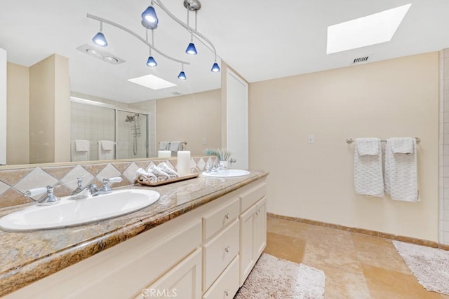 bathroom with a shower with door, vanity, and a skylight