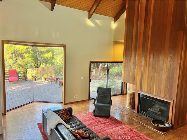 living room featuring wood ceiling, hardwood / wood-style floors, high vaulted ceiling, and beamed ceiling