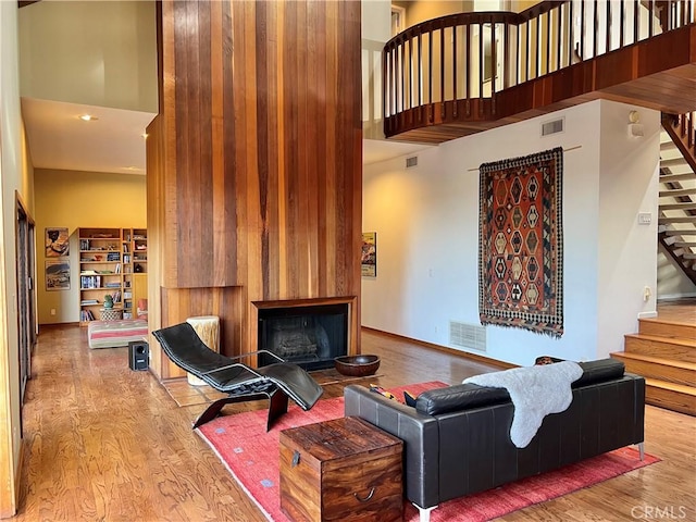 living room with a towering ceiling and light hardwood / wood-style floors