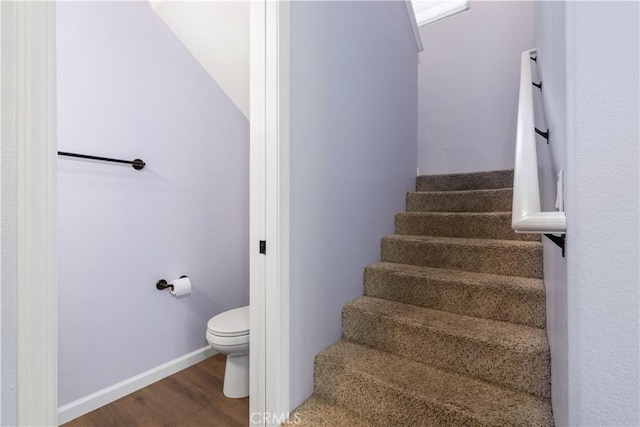 stairway with wood-type flooring and lofted ceiling