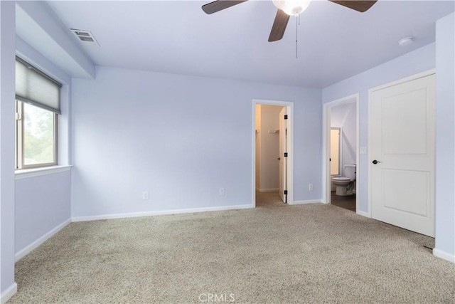 unfurnished bedroom featuring connected bathroom, ceiling fan, light colored carpet, and a walk in closet