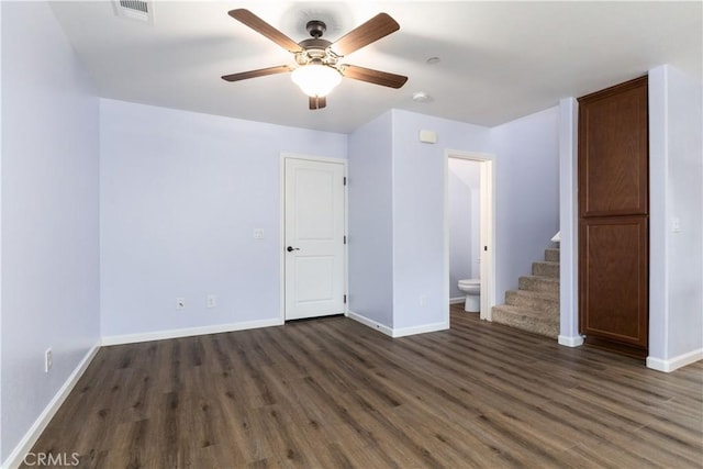 empty room with ceiling fan and dark hardwood / wood-style flooring