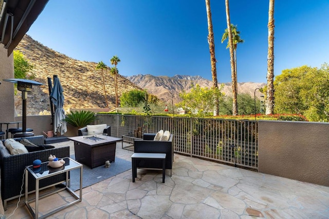 view of patio / terrace featuring a mountain view and an outdoor living space with a fire pit