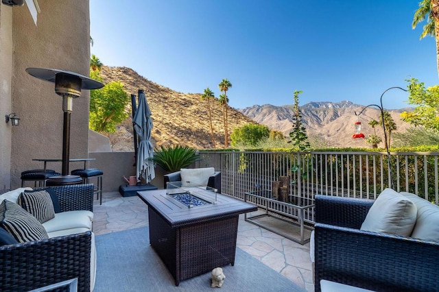 view of patio / terrace featuring a mountain view and an outdoor living space with a fire pit