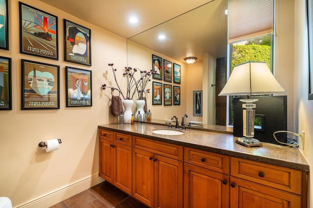 bar with dark tile patterned flooring, sink, and dark stone counters