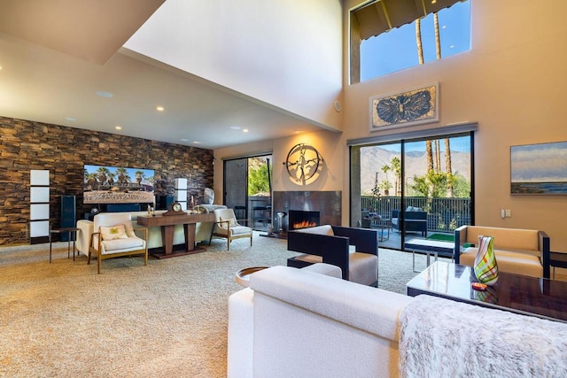 living room featuring carpet, a healthy amount of sunlight, and a high ceiling