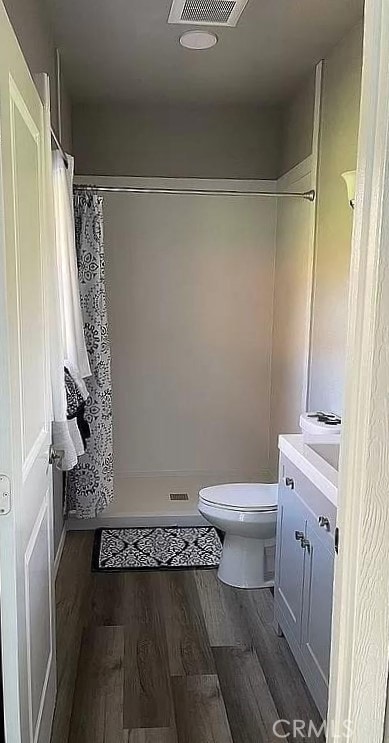 bathroom with hardwood / wood-style flooring, vanity, toilet, and a shower with shower curtain