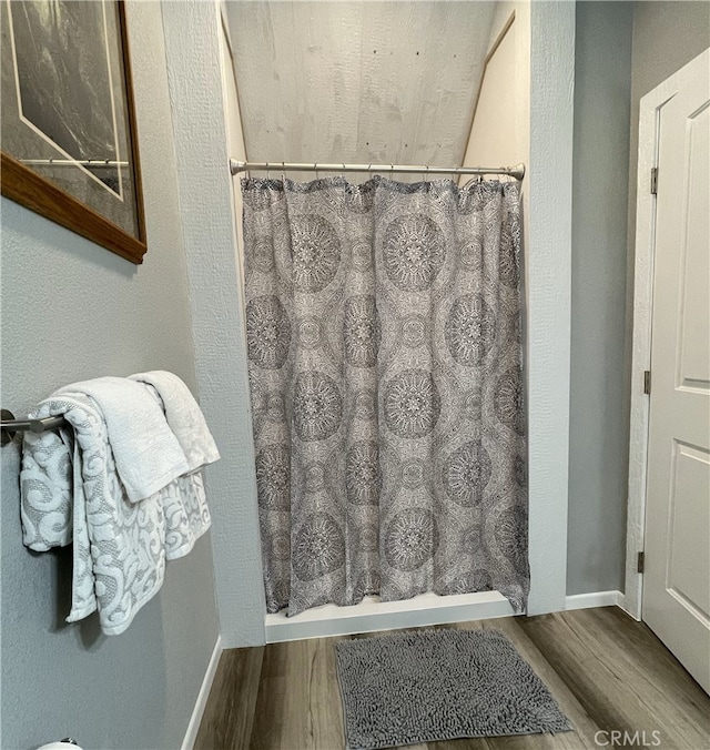 bathroom with hardwood / wood-style floors and a shower with shower curtain