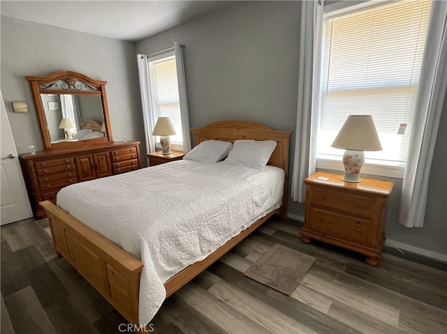 bedroom featuring dark hardwood / wood-style flooring and multiple windows