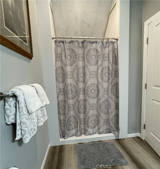 bathroom featuring a shower with curtain and hardwood / wood-style floors