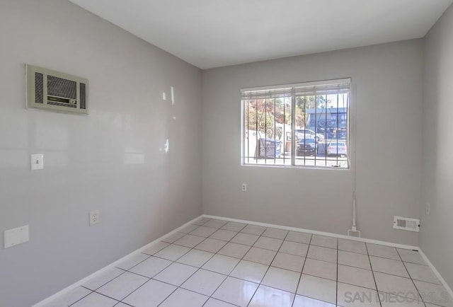 spare room with a wall mounted air conditioner and light tile patterned floors