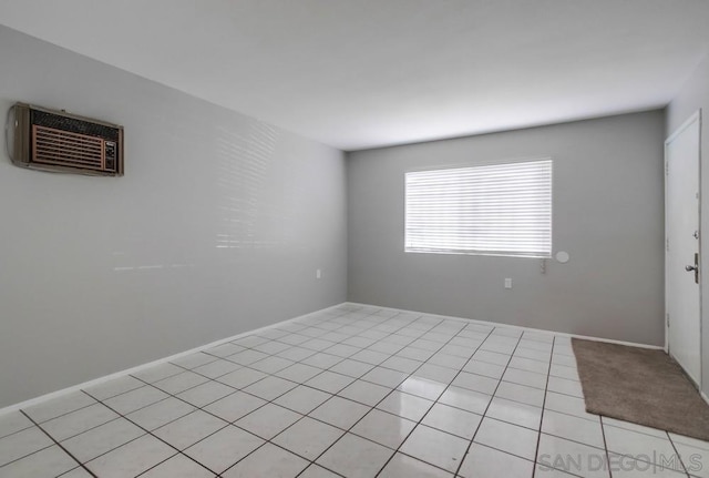 tiled spare room featuring a wall mounted AC