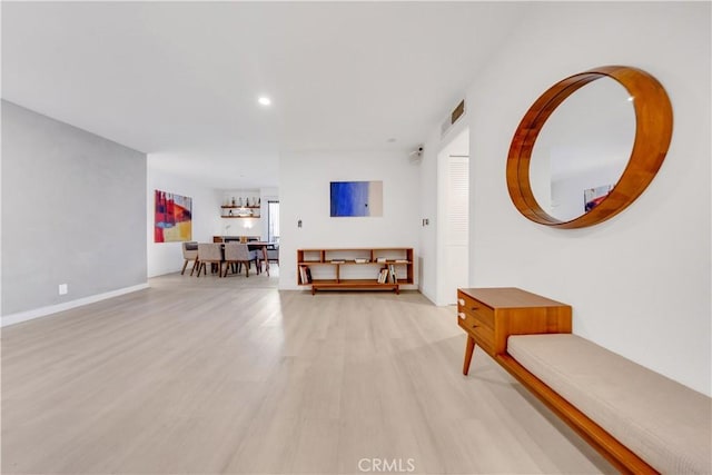 hall featuring a notable chandelier and light wood-type flooring