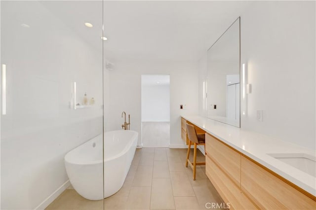 bathroom with tile patterned floors, a bathtub, and vanity