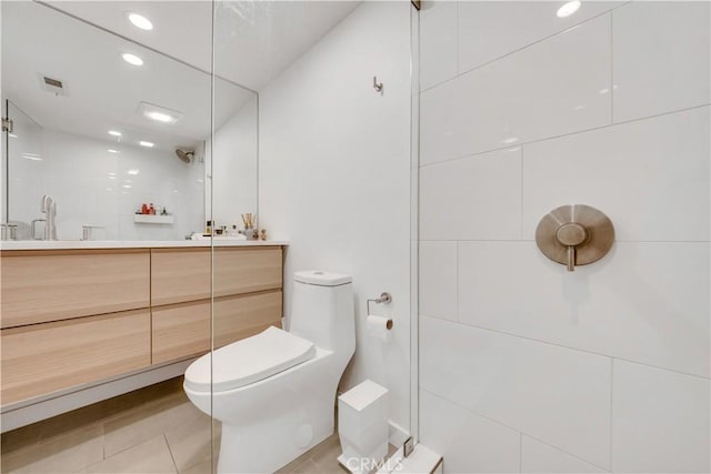 bathroom featuring walk in shower, tile patterned flooring, vanity, and toilet