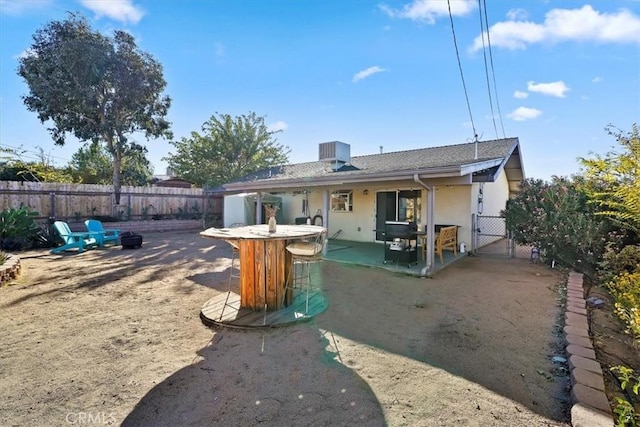 rear view of house featuring a bar, cooling unit, and a patio area