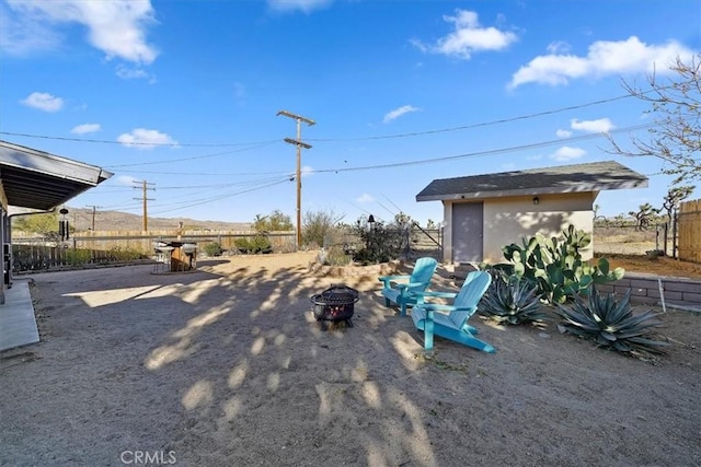 view of yard with a fire pit and a storage shed