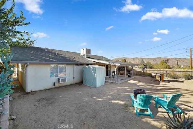 back of house with a fire pit, a mountain view, cooling unit, and a patio area