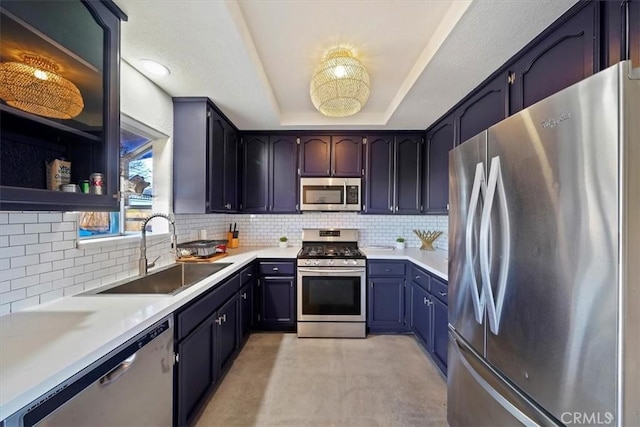 kitchen featuring backsplash, sink, a tray ceiling, and stainless steel appliances