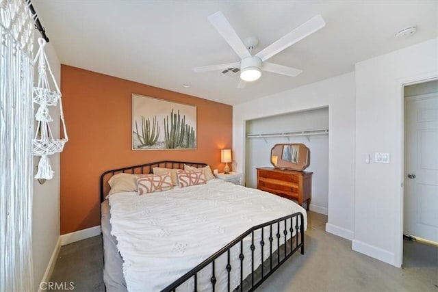 bedroom with ceiling fan, concrete flooring, and a closet