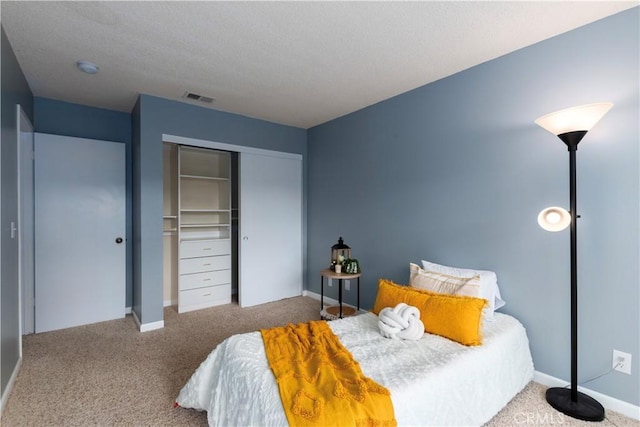 carpeted bedroom featuring a closet and a textured ceiling