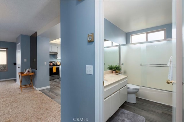 full bathroom with toilet, vanity, wood-type flooring, and combined bath / shower with glass door