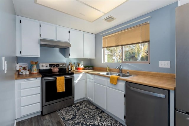 kitchen featuring white cabinets, appliances with stainless steel finishes, dark hardwood / wood-style flooring, and sink