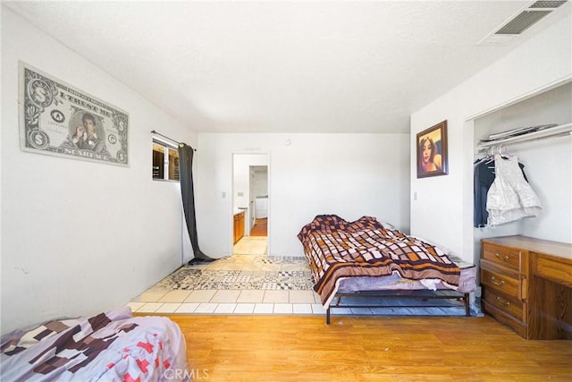 bedroom featuring light wood-type flooring and a closet