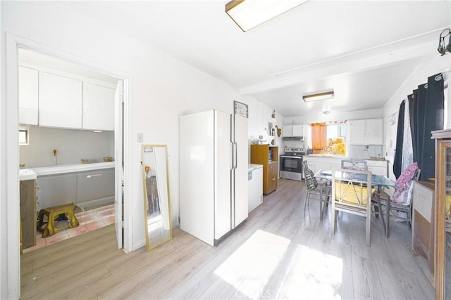 kitchen featuring stainless steel electric stove, light hardwood / wood-style flooring, and white cabinets