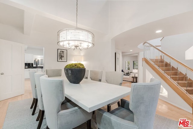 dining space featuring light hardwood / wood-style flooring and a notable chandelier