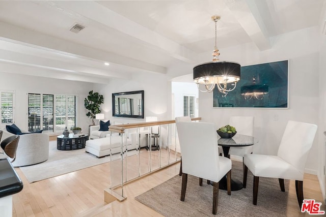 dining room with a notable chandelier, hardwood / wood-style flooring, and beamed ceiling