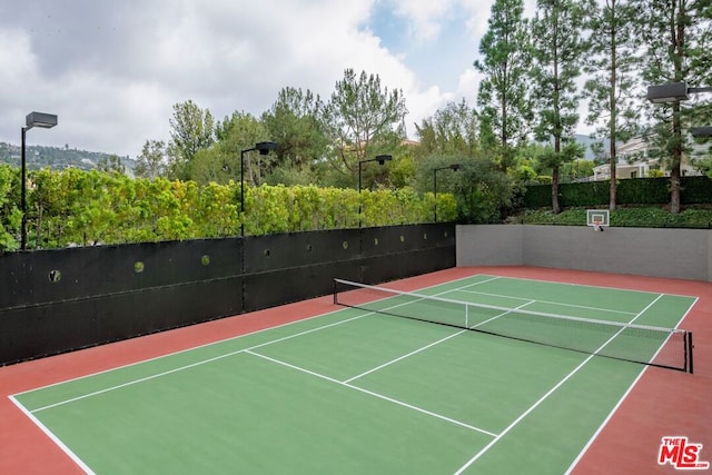 view of tennis court with basketball hoop